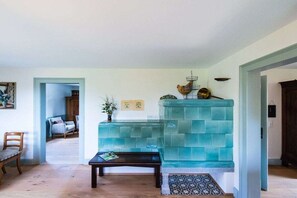 Ein Zimmer mit einer wandfarbenen Akzentwand in Türkis, einer Holzbank, einem kleinen Tisch und einer Tür zu einem anderen Raum.