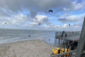 A beach with a pier and multiple kites in the sky. - Holiday home in Renesse with swimming pool (Renesse)