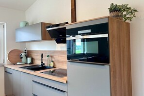 A modern kitchen with a built-in oven, a coffee machine, and a sink. - Schottenhof Walser 3 (Achberg)
