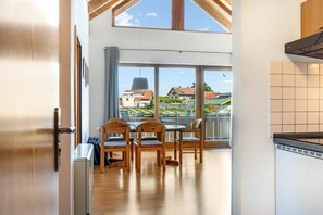Una cucina moderna con un'ampia finestra, sedie in legno e un tavolo da pranzo.