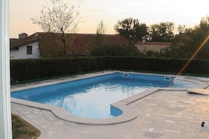 A rectangular swimming pool with a tiled deck surrounding it. - Wellness holiday apartment Graf Schumann (Röhrnbach)