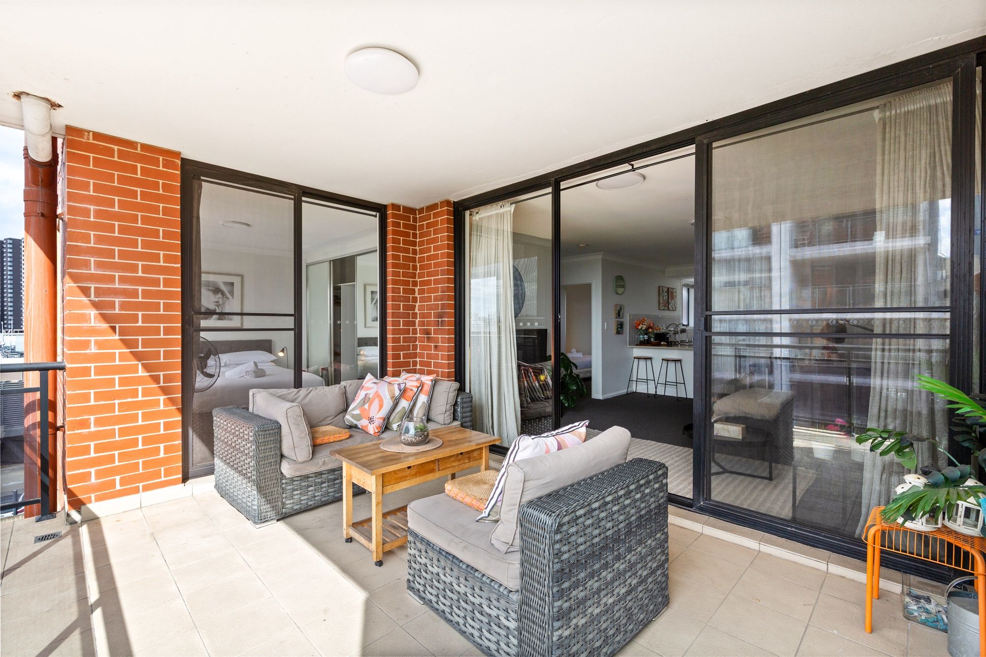 A modern living room with a sofa, a coffee table, and a dining area with a chair and table.
