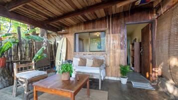 Una cabaña de madera con una mesa, dos sillas, un banco y una ventana.