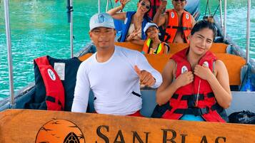 Ein Boot mit einem Schild, auf dem 'SAN BLAS LUXURY TOUR' steht, und Personen in Schwimmwesten.