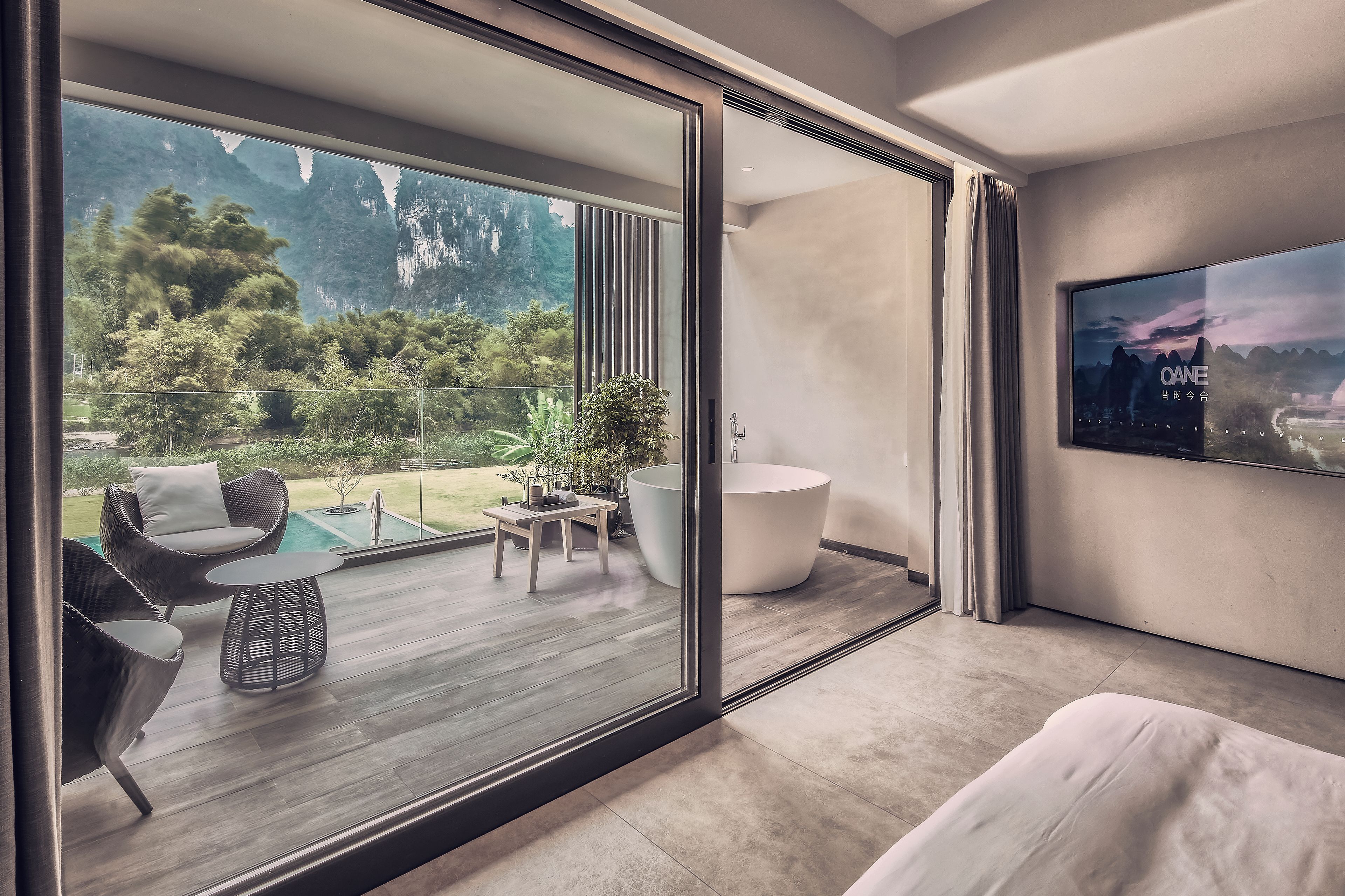 A modern interior with a large sliding glass door leading to an outdoor patio area.