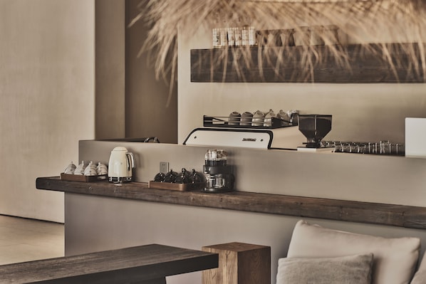 A modern kitchen with a coffee machine, tea set, and a rustic wooden table. - The Heart of Karst Riverside Retreat (Guilin)