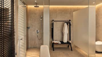 Un baño moderno con ducha a ras de suelo, un banco y un perchero.
