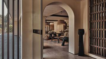 Un ambiente interno dal design moderno, con un arco che dà accesso a una zona pranzo con tavolo e sedie.