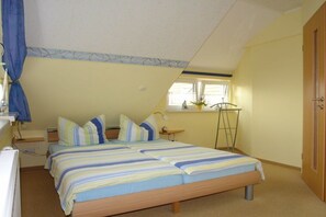 A bedroom with a bed, bedside tables, a window, and a door. - Small seagull's nest (Heringsdorf)
