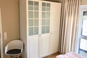 A room with a large wardrobe, a chair, and a bed. - Holiday apartment with 2 bedrooms (Grömitz)