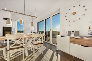 A modern kitchen with a dining area, large windows, and a view of the outdoors. - Holiday apartment in Glowe with swimming pool (Glowe)