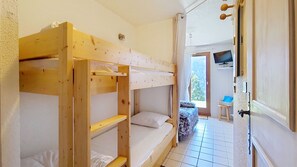 A room with bunk beds, a television, and a door leading outside. - AGA2 VIEW & MOUNTAIN Alpine Chalet (3 People) (Châtel)
