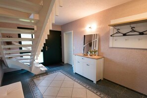 A staircase leading to a landing with a white cabinet and a mirror on the wall. - Holiday home in Lübbenau with swimming pool (Lübbenau)