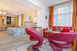 A hotel room with a bed, a sofa, a dining table, and a chair. - Sorrento, Villa Glückpilz (Binz)