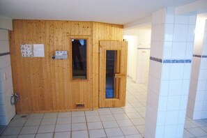 A room with wooden paneling, a tiled floor, and a door leading to a bathroom. - Sorrento, Villa Glückpilz (Binz)