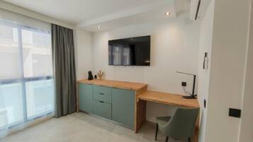 Una cocina moderna con encimera de madera, armarios verde azulado y estufa integrada.