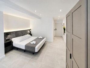 Una camera da letto moderna con un letto, comodini e un armadio.