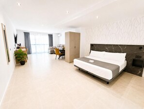 Una moderna camera d'albergo con un letto, una scrivania, una sedia e un armadio.
