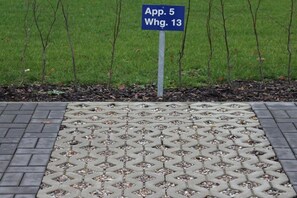 A paved area with a geometric pattern, a signpost with text, and a grassy background. - Holiday apartment with 2 bedrooms (Großenbrode)