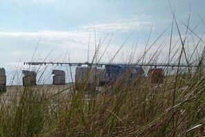 A beach with a pier extending into the water, surrounded by tall grasses. - Holiday apartment with 2 bedrooms (Großenbrode)