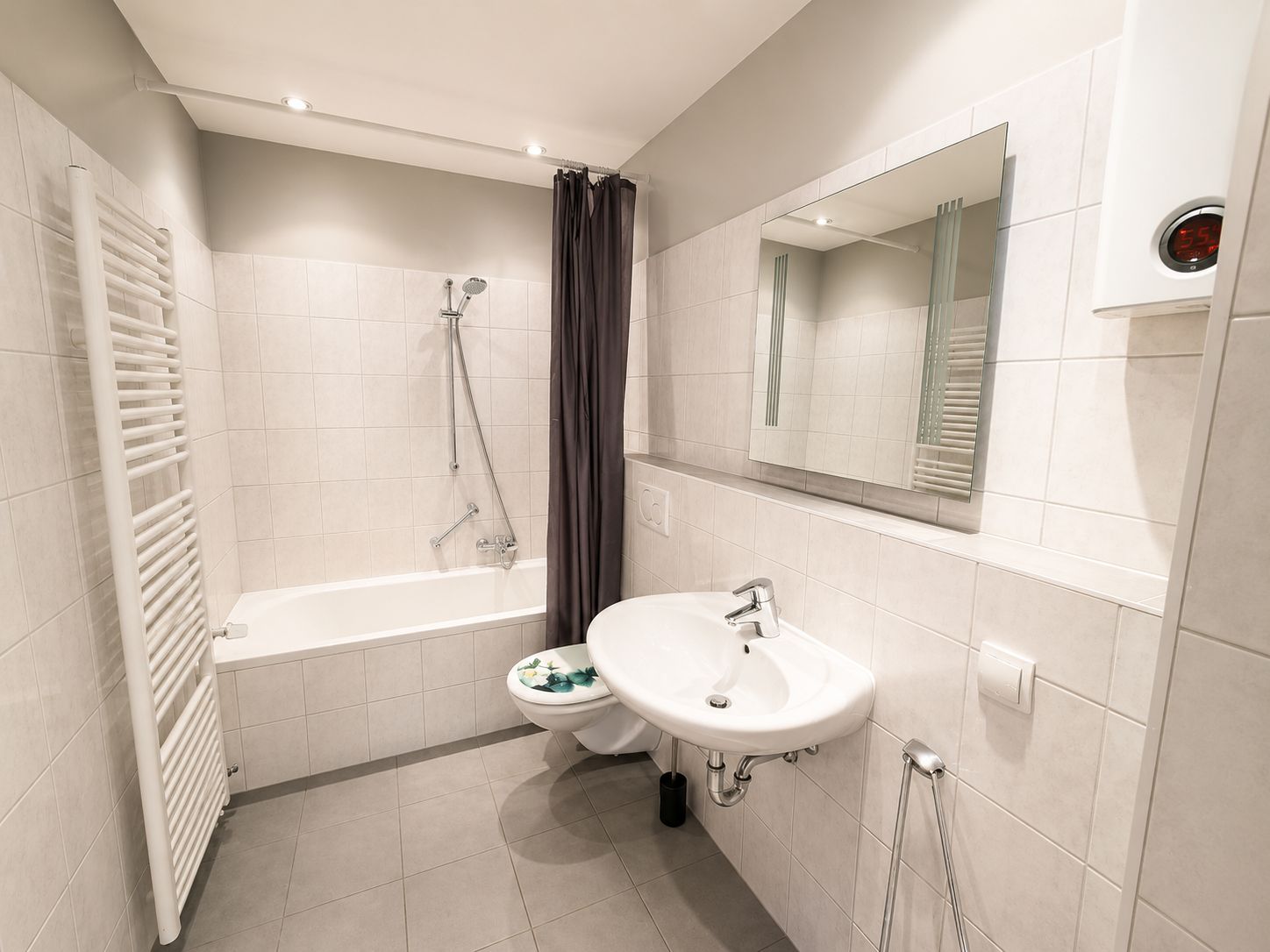 Ein modernes Badezimmer mit Badewanne, Toilette und Waschbecken.