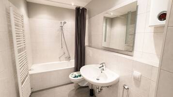 Ein modernes Badezimmer mit Badewanne, Toilette und Waschbecken.