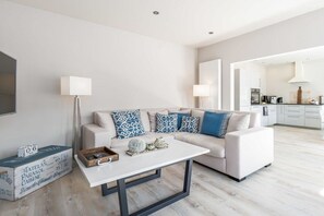 A modern living room with a sofa, coffee table, and decorative items. - Holiday home with 2 bedrooms (Heiligenhafen)