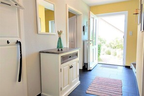 A hallway with a white cabinet, a mirror, and a door leading outside. - Holiday home in Kappeln with swimming pool (Kappeln)
