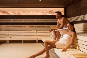 Eine Sauna mit Holzbänken und einer Wandmalerei von Bergen.