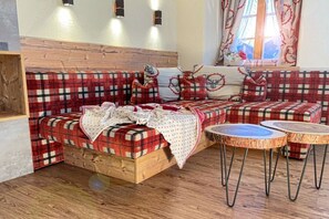 Ein gemütliches Zimmer mit einem Holzbett, Karo-Bettwäsche und einem Fenster mit Vorhängen.