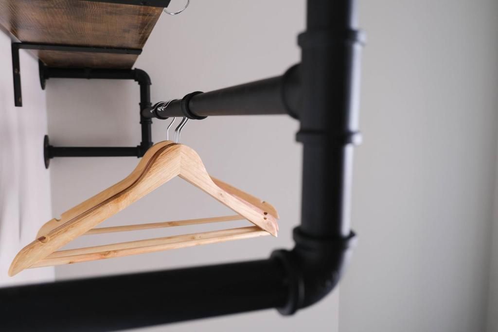 A wooden hanger on a black metal rack.