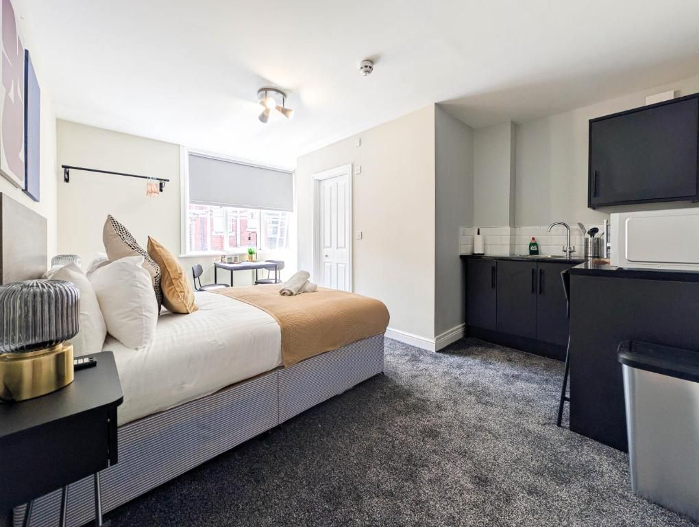 A modern hotel room with a bed, bedside table, and a view of the city.