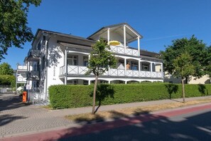 A two-story building with a balcony, a covered entrance, and a red bike lane. - 22, Residence Dünenstraße (Binz)