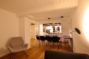 Ein modernes Interieur mit Essbereich, Küche und einem Stuhl.