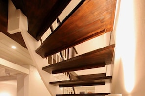 Eine Treppe mit Holzbalken und einer weißen Wand.