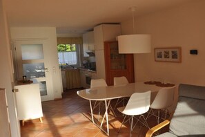 A compact living space with a dining area, kitchenette, and a sofa. - Holiday home in the Baltic Sea resort of Rerik with Wi-Fi (Ostseebad Rerik)
