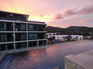A modern building with multiple floors and a rooftop pool. - Top-floor Sea-view Studio, Nai Harn, Rooftop Pool (Rawai)