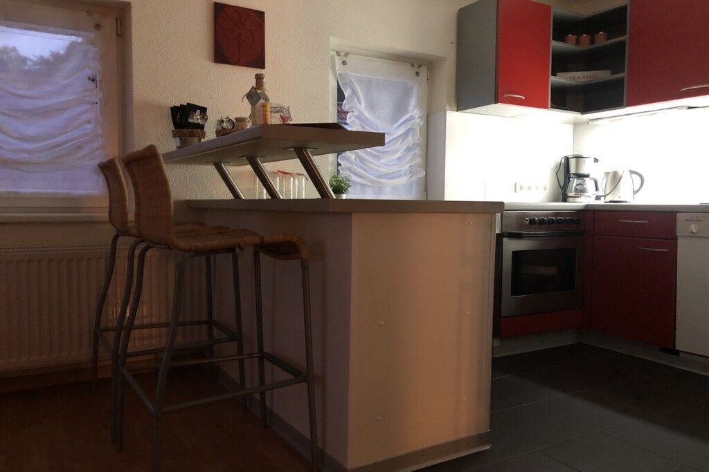 Eine Küche mit einer Bar, Barhocker, einer Kaffeemaschine und einem Herd.