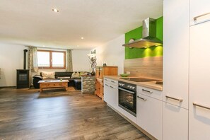 Eine moderne Küche mit weißen Schränken, einem eingebauten Backofen und einer grünen Spritzschutzwand.