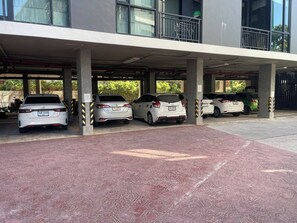 A covered parking area with multiple cars parked under a building. - Quiet Sea-view Studio, Walk to Nai Harn Beach (Rawai)