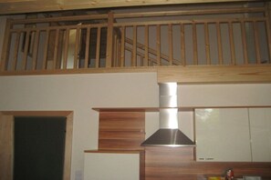 Eine Küche mit Holzbalkendecke und einer Edelstahl-Dunstabzugshaube.