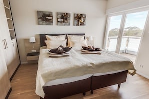 Ein Schlafzimmer mit einem großen Bett, einem Nachttisch und einem Fenster mit Blick.