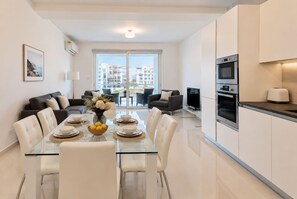 A modern apartment with a dining area, kitchen, and living space. - Bright 2BR Flat in St. Julian's - Balcony & Views (St. Julian's)