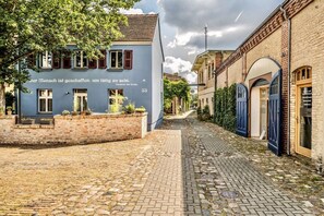 A cobblestone street with buildings on either side, one with a sign in a foreign language. - Holiday apartment with 1 bedroom (Werder\/Havel)