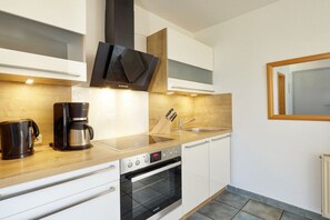 A modern kitchen with a built-in oven, a coffee maker, and a sink. - House by the dike, Mill 1, ground floor, 60m² (Prerow)