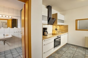 Eine moderne Küche mit Backofen, Kaffeemaschine und Spüle.
