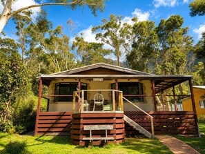 Eine Holzhütte mit Veranda, einer Treppe und einem Schild, das ein 'Lodge' anzeigt.