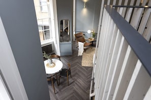A room with a dining table, chairs, a mirror, a small side table with a lamp, and a radiator. - Georgian Townhouse Studio, Heart of Edinburgh (Edinburgh)