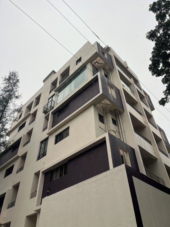 Un immeuble à plusieurs étages doté de balcons, de grandes fenêtres et d’un style architectural moderne.
