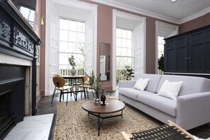 Ein Wohnzimmer mit Kamin, einer Couch, einem Couchtisch und einem Essbereich mit Stühlen und einem Tisch.